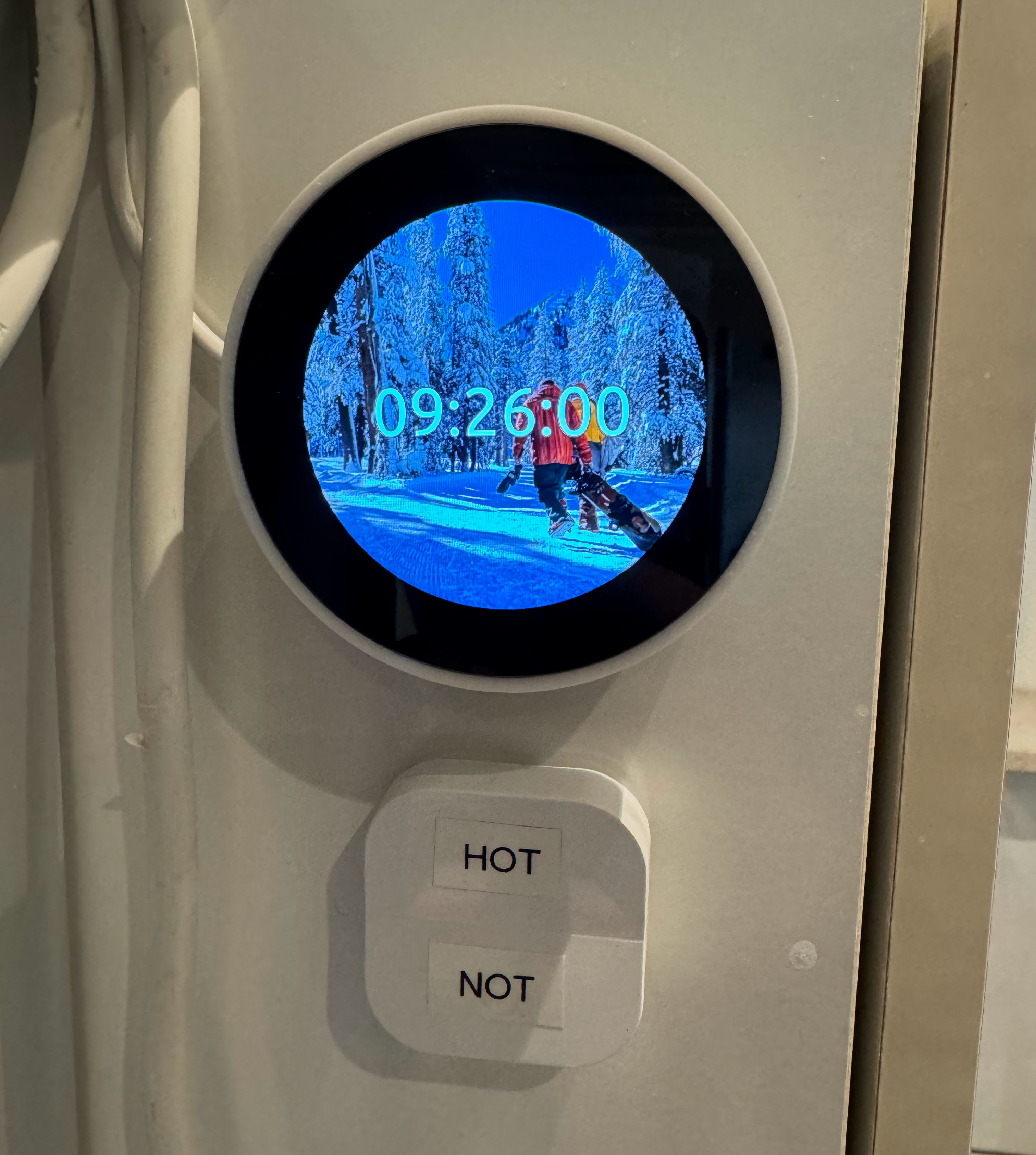 Round LCD showing a thermostat in a bathroom